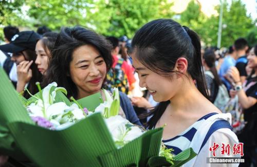 资料图：山东济南众多考生手捧鲜花在家长的簇拥下欢快告别高考。<a target='_blank'  data-cke-saved-href='http://www.chinanews.com/' href='http://www.chinanews.com/'>中新社</a>记者 张勇 摄