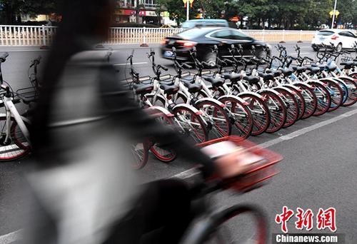 资料图:路人骑着共享单车经过“车堆”。<a target='_blank' data-cke-saved-href='http://www.chinanews.com/' href='http://www.chinanews.com/'>中新社</a>记者 张斌 摄 资料图:路人骑着共享单车经过“车堆”。<a target='_blank' data-cke-saved-href='http://www.chinanews.com/' href='http://www.chinanews.com/'>中新社</a>记者 张斌 摄